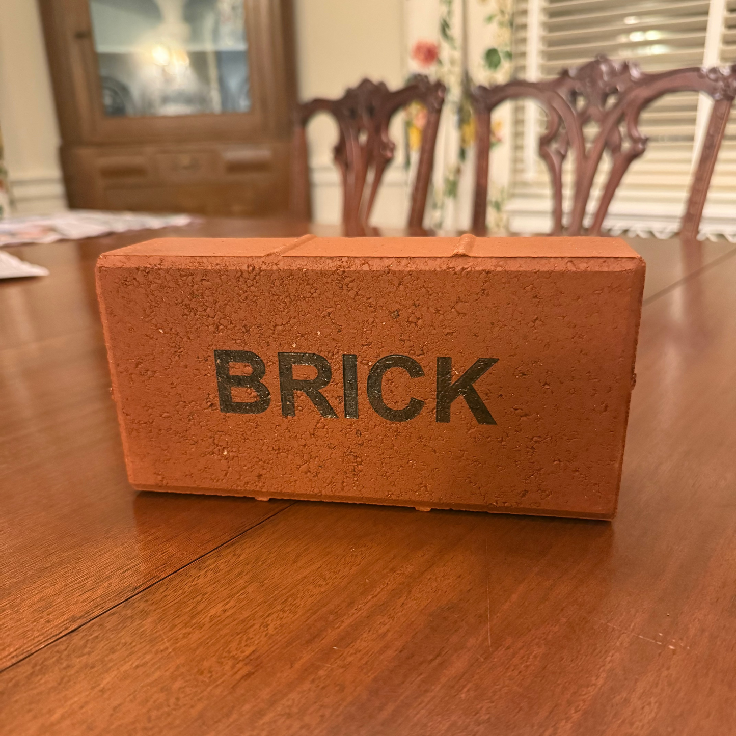 Model brick with 'BRICK' text on a wooden table