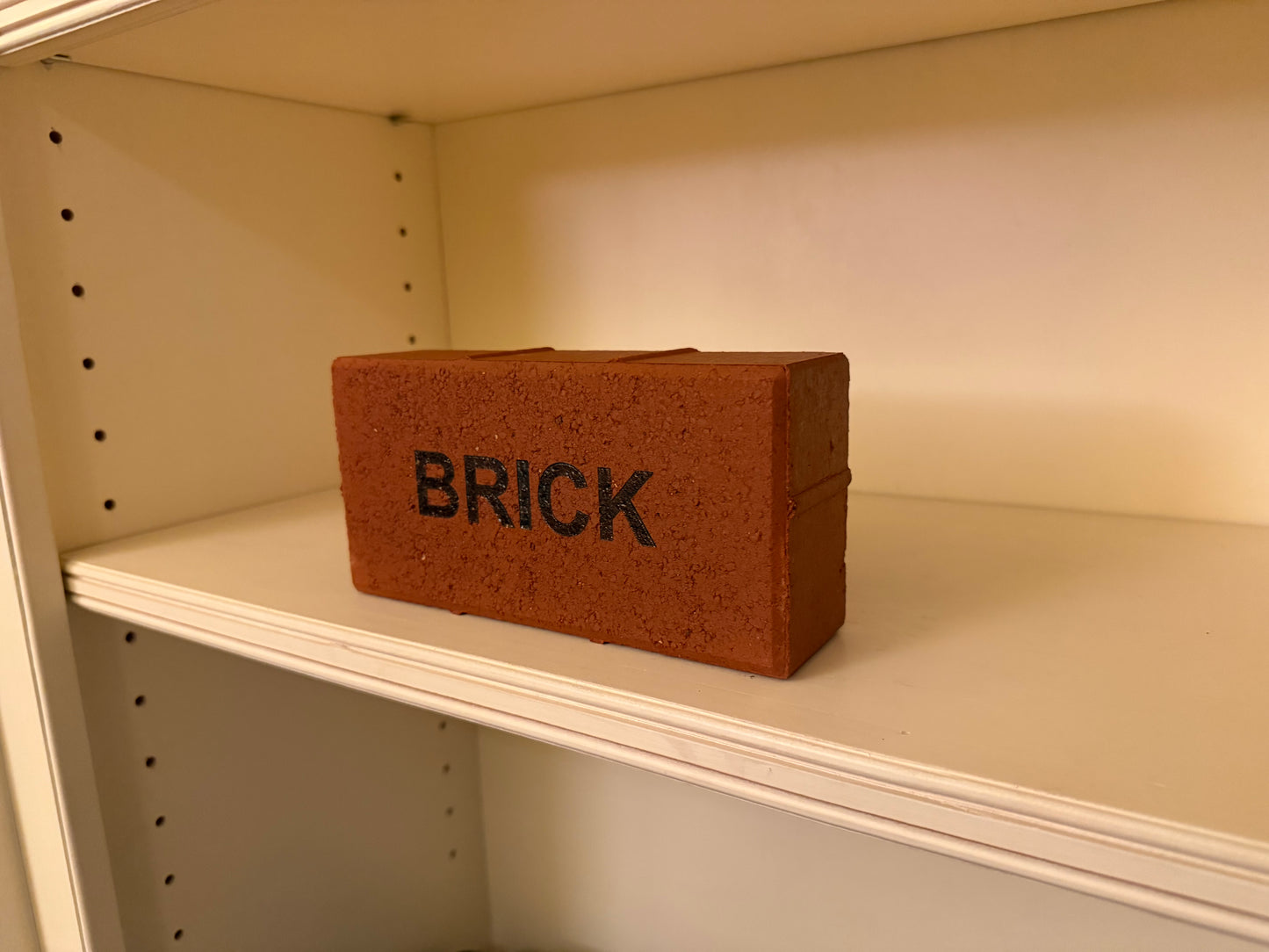 Small brick-shaped container labeled 'BRICK' on a shelf