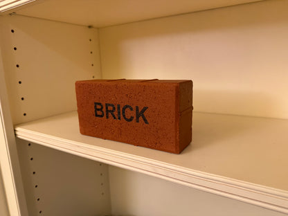 Small brick-shaped container labeled 'BRICK' on a shelf